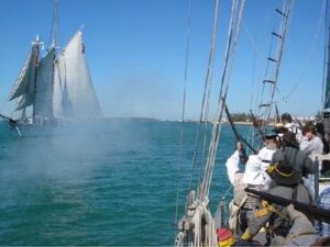 Confederate soldiers on sailing ship fire at Union ship during Civil War Heritage Days.